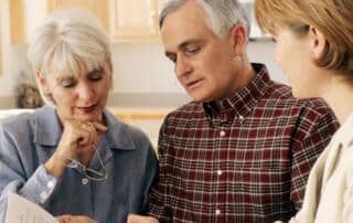 An older couple talking with their estate planning attorney, reviewing their options.