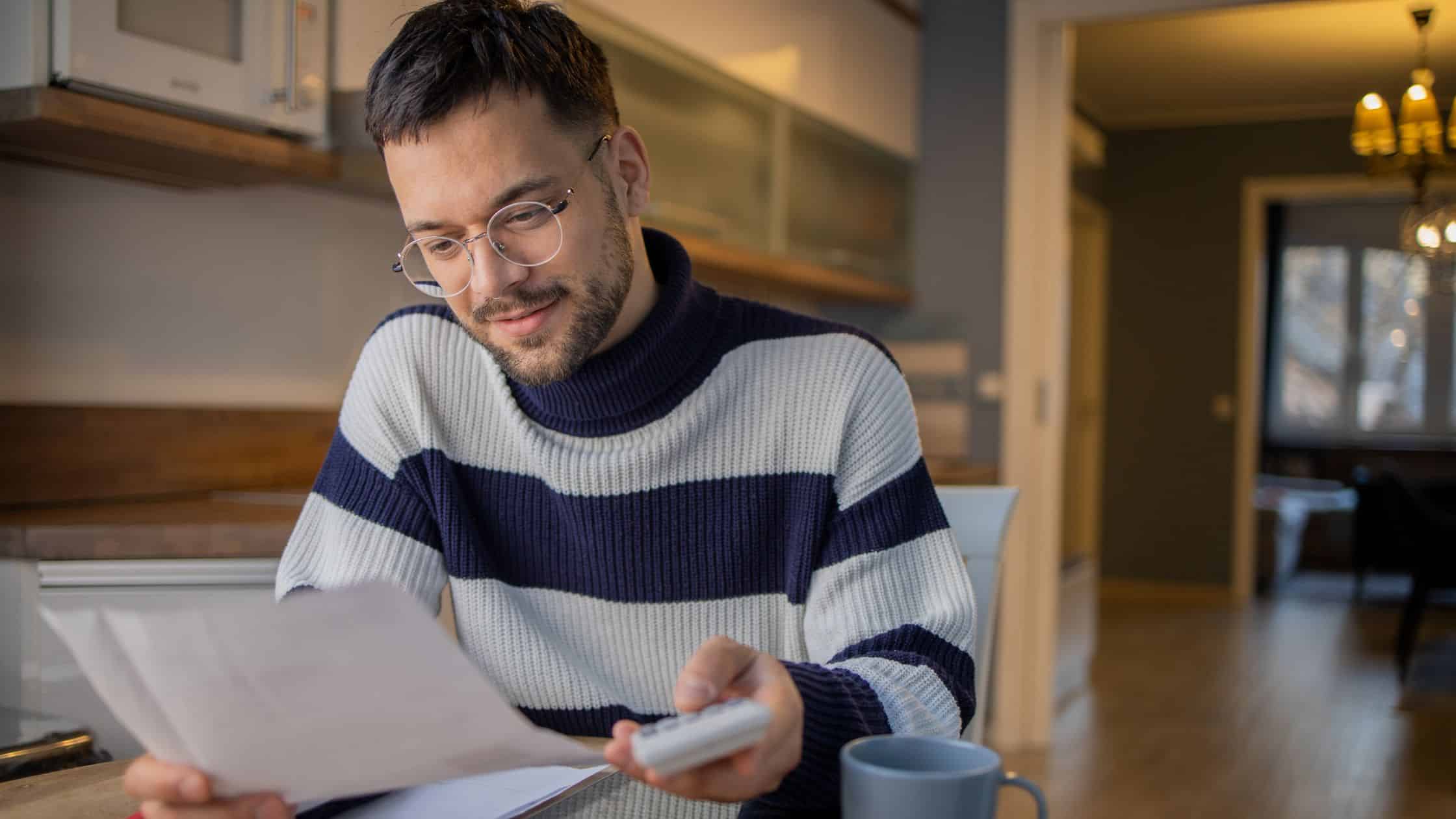 A man in a striped sweater working on tax returns.