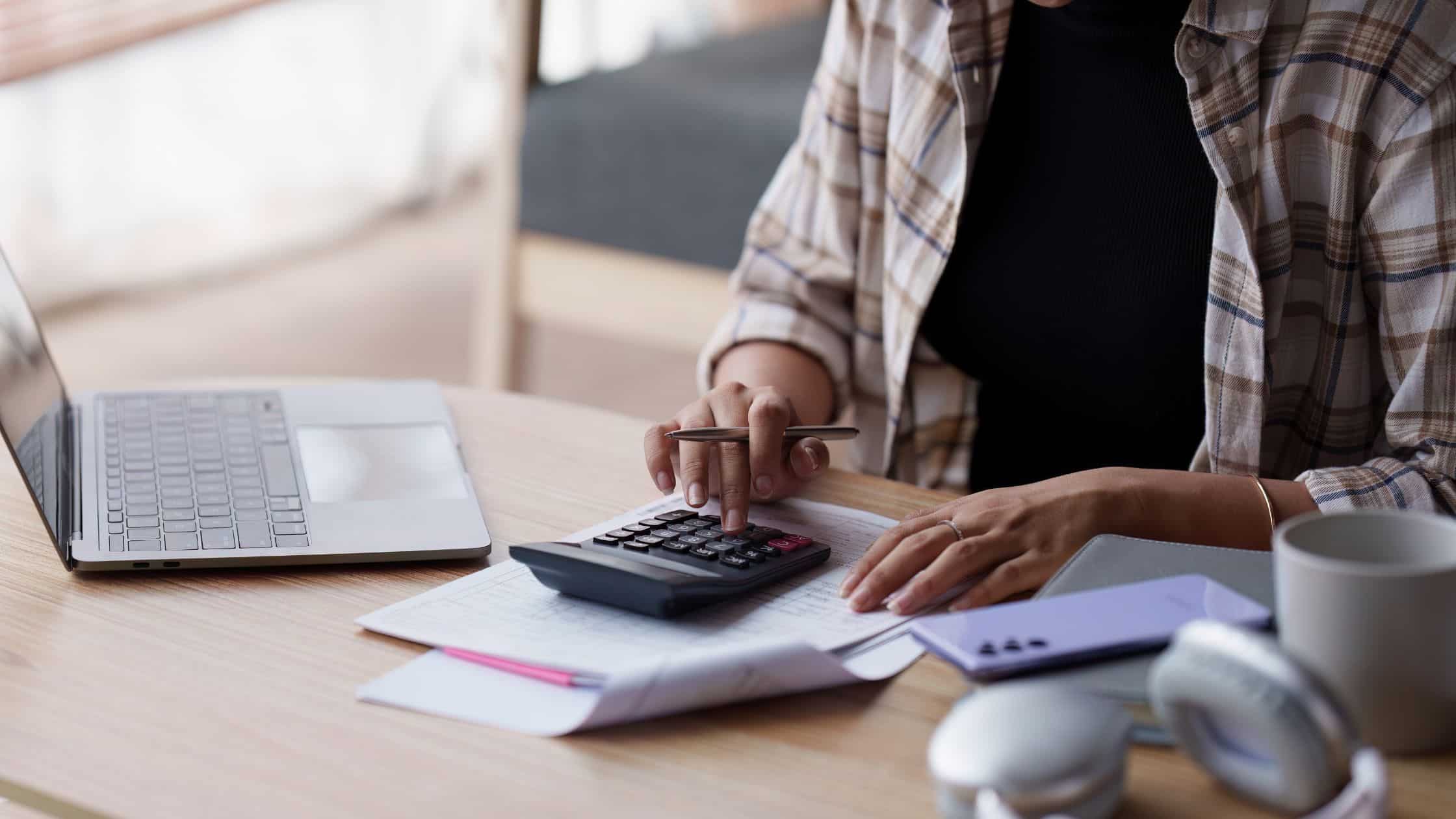 A person working on a calculator to determine expenses and payments.