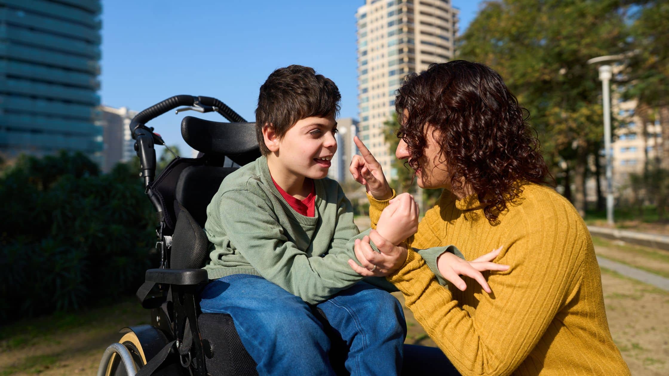 A mother playing with her son, who is in a wheelchair.